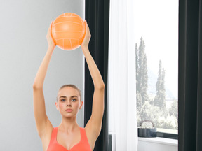 A woman holding a basketball up in the air