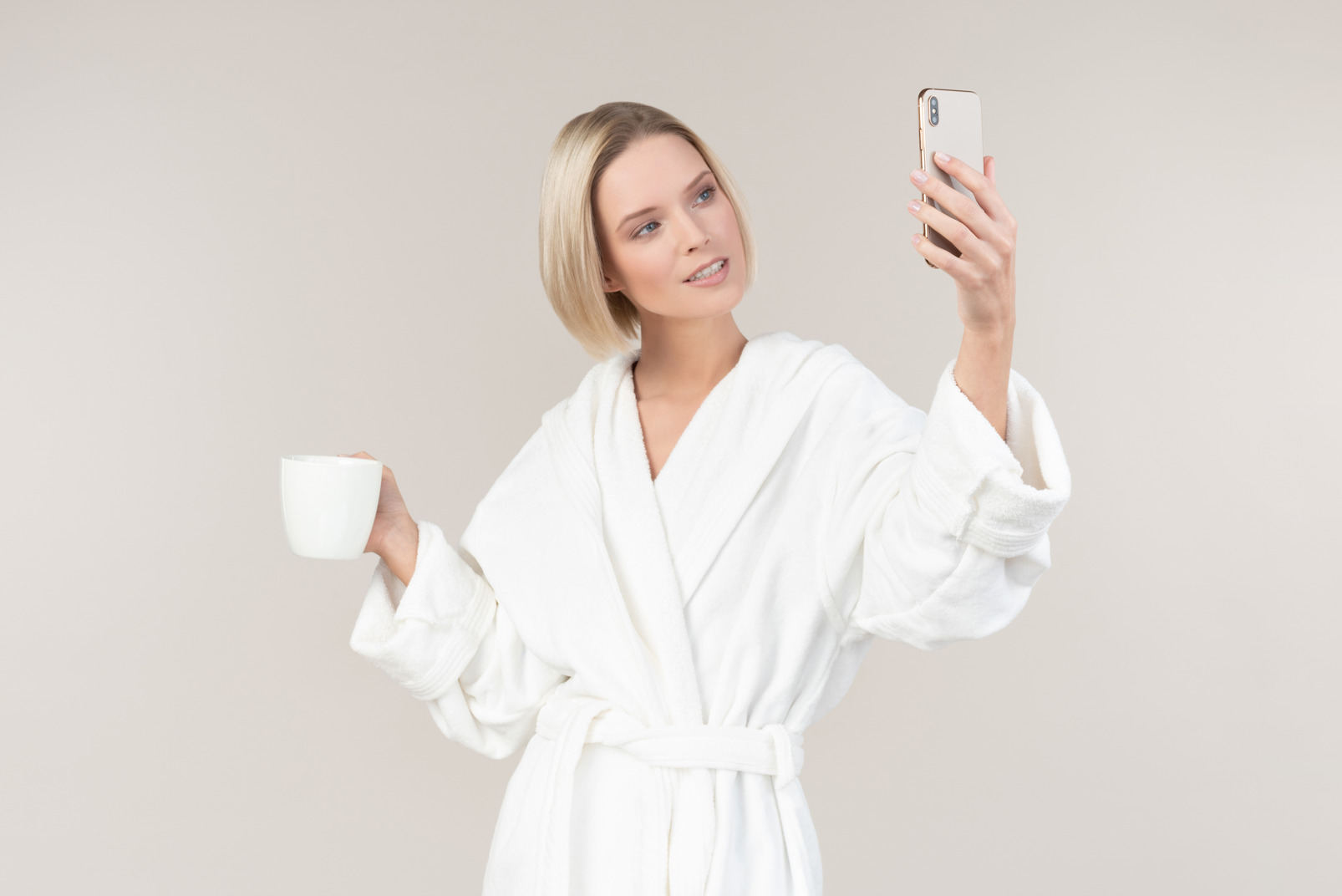 Young girl holding mug and smartphone