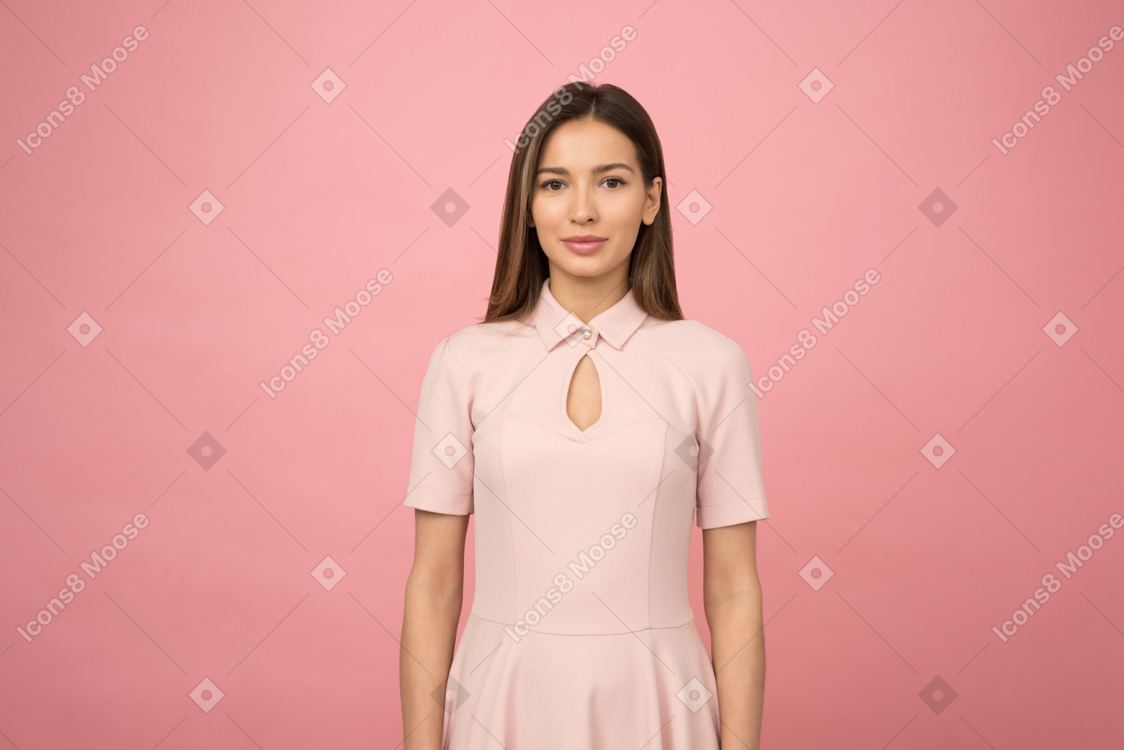Ragazza in un vestito rosa in piedi in uno studio rosa