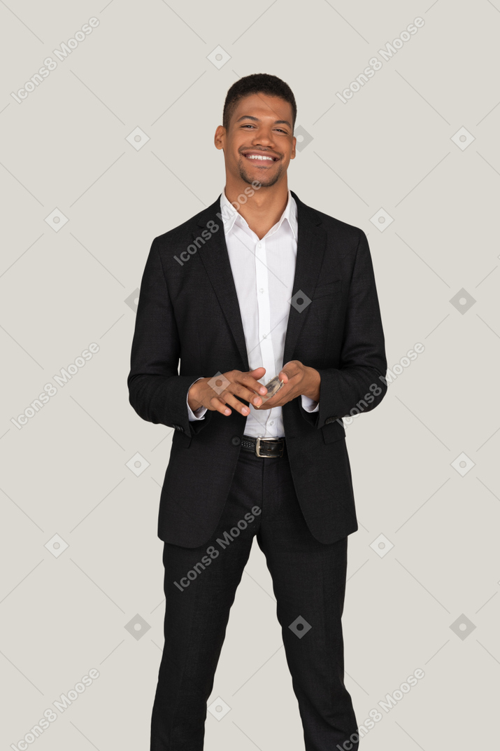 Front view of a young man in black suit wasting money