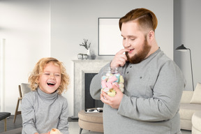 Sieht aus wie ein großer vater kann sich nicht davon abhalten, süßigkeiten zu essen