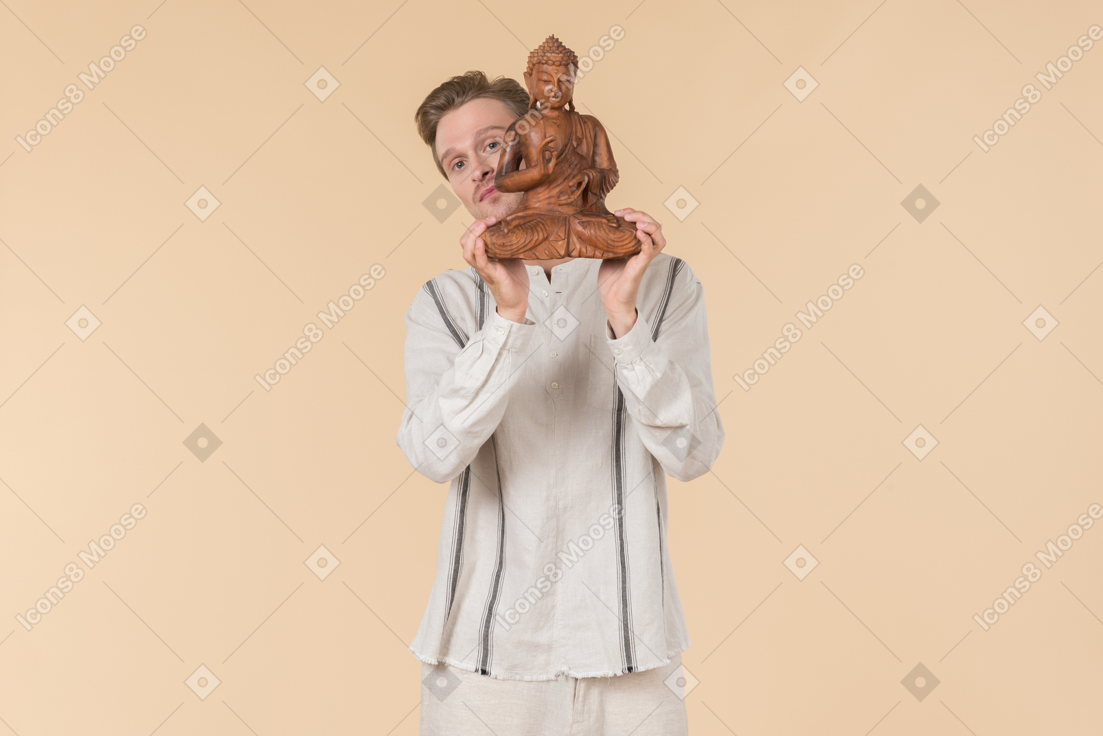Young caucasian man holding buddha statue