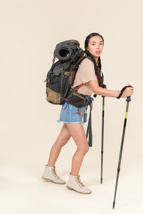 Donna escursionista a piedi con bastoncini da trekking