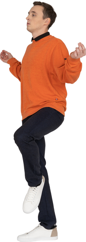 橙色运动衫摆姿势的年轻人