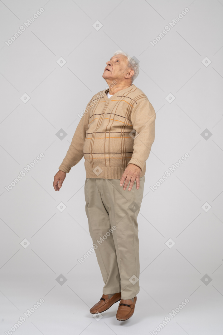 カジュアルな服を着てジャンプする老人の正面図