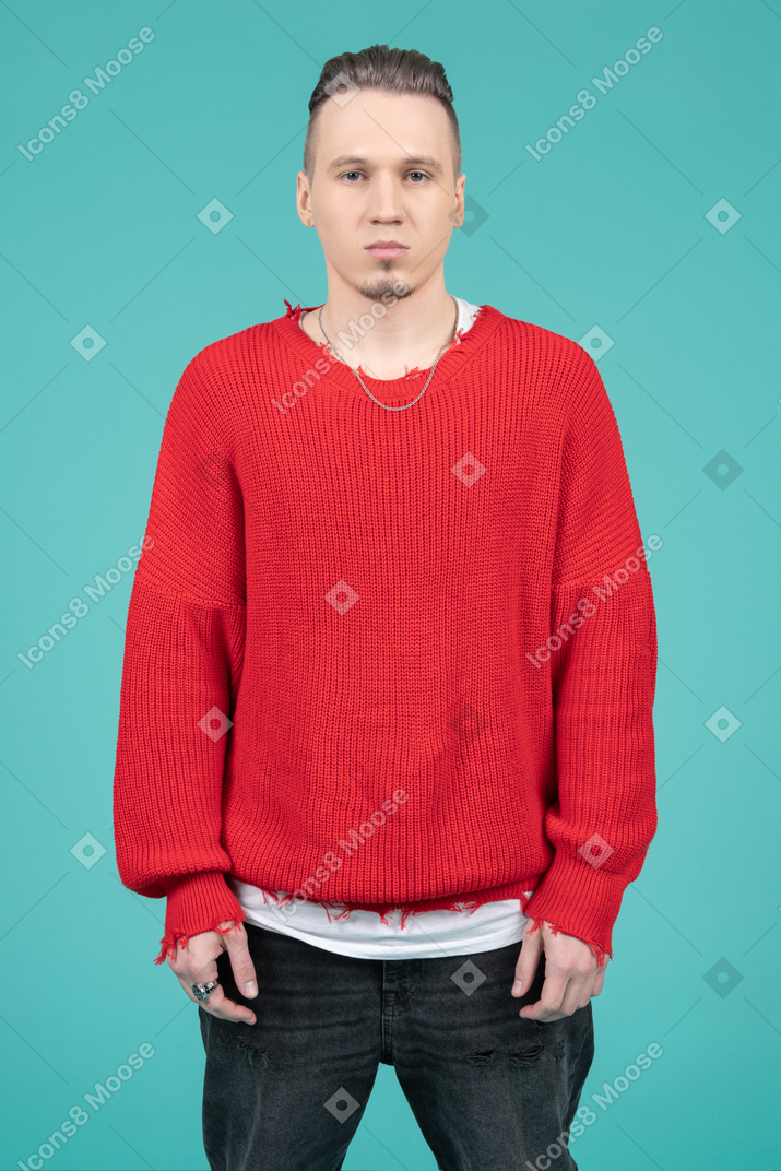 Sad looking young man standing against camera
