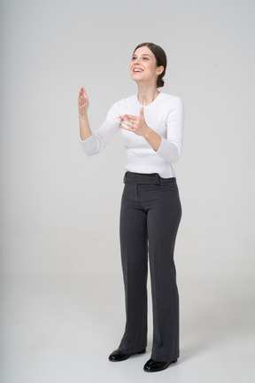 Front view of a woman in suit looking up and gesturing