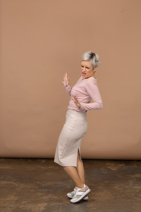 Vista lateral de uma mulher emocional em roupas casuais, mostrando um gesto de parada