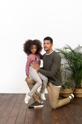 Young man on a knee with his daughter