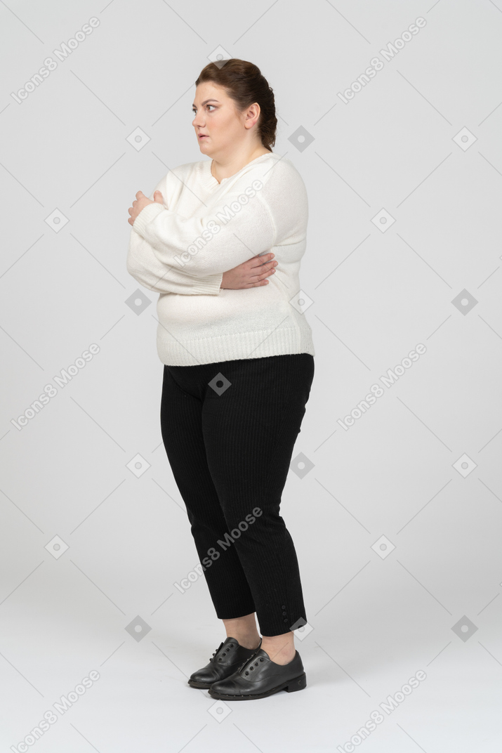 Plump woman in casual clothes posing with arms crossed