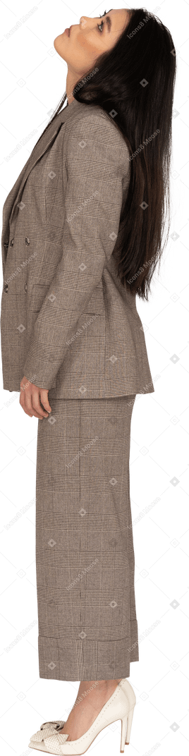 頭を上げる茶色のビジネススーツの若い女性の側面図
