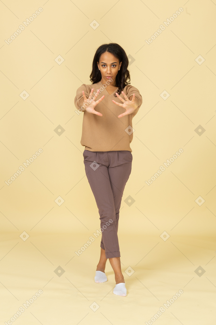 浅黒い肌の若い女性の手を伸ばして正面図