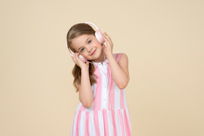 Cute little girl in the headphones listening to a music