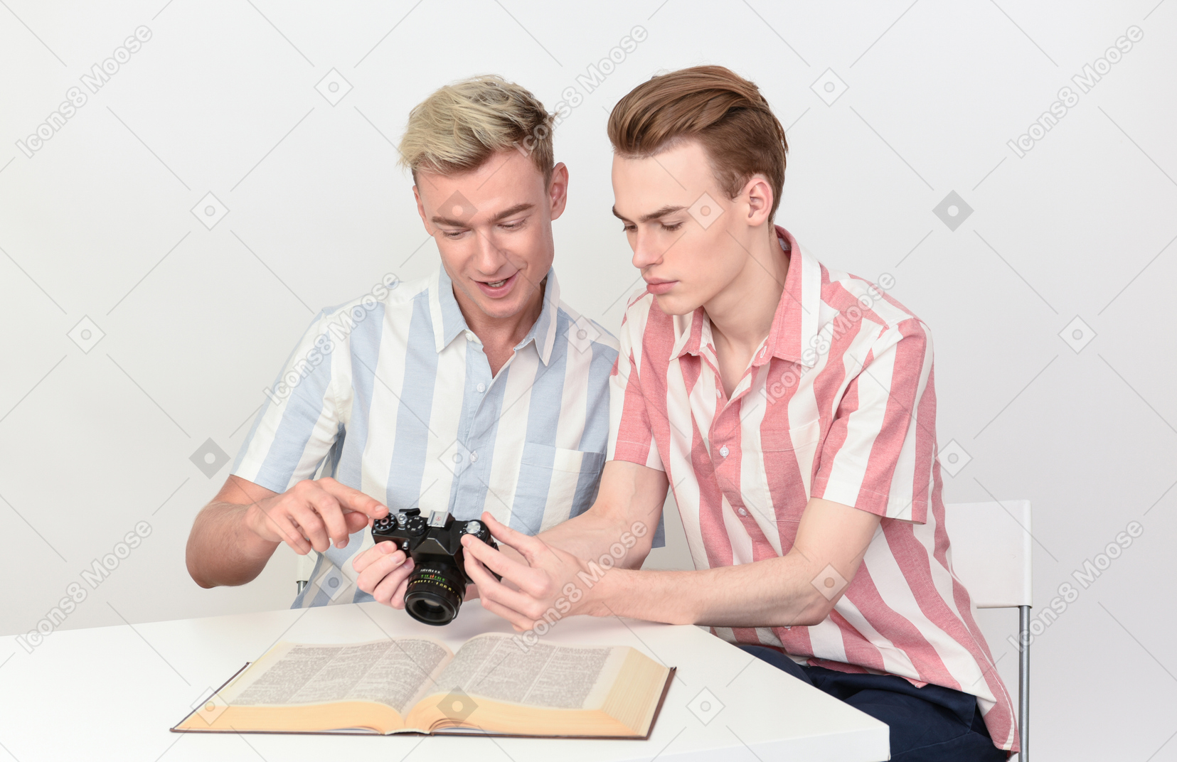 Coppia gay seduti al tavolo e calcolando le impostazioni della fotocamera