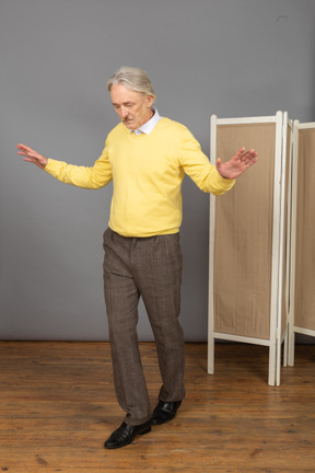 Vista di tre quarti di un uomo anziano che cammina in equilibrio