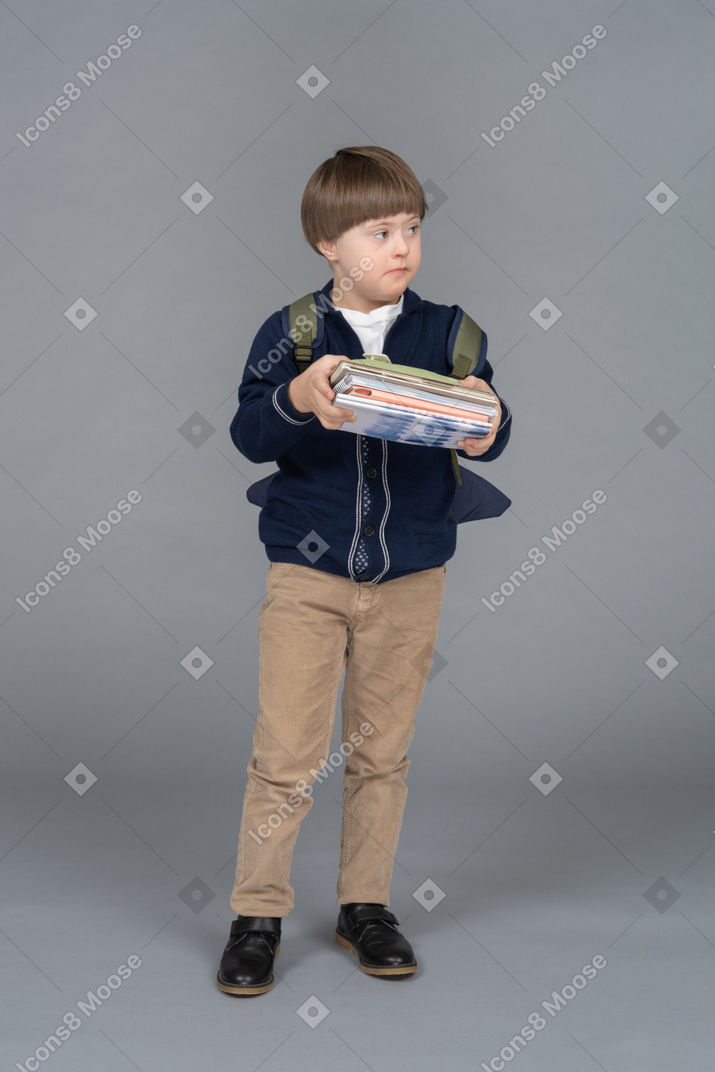 Portrait of a schoolboy holding a pile of books
