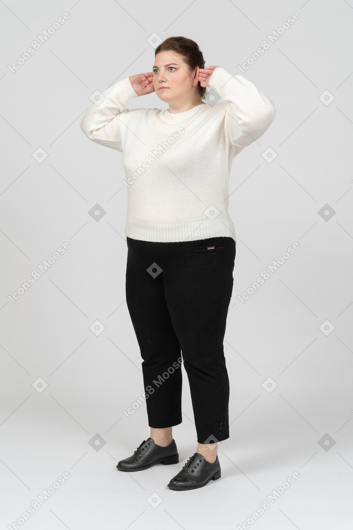 Plump woman in casual clothes touching ears