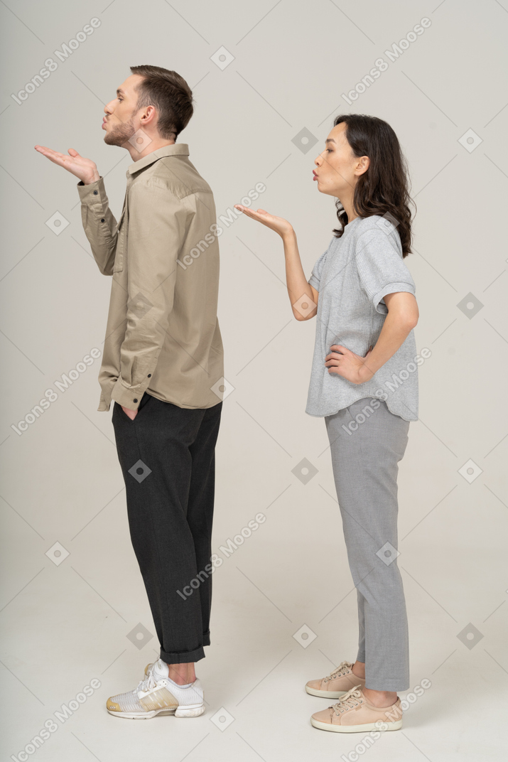 Side view of young couple blowing a kiss