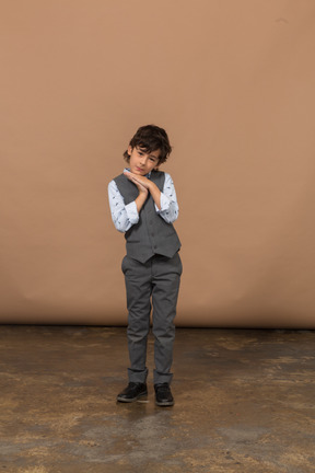 Vista frontal de un chico lindo en traje gris