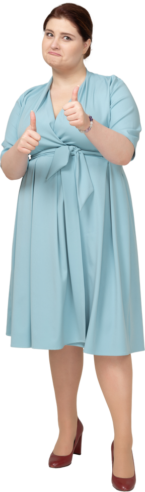 Front view of a woman in blue dress showing thumbs up
