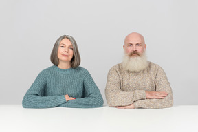 Couple âgé assis à la table, les mains jointes