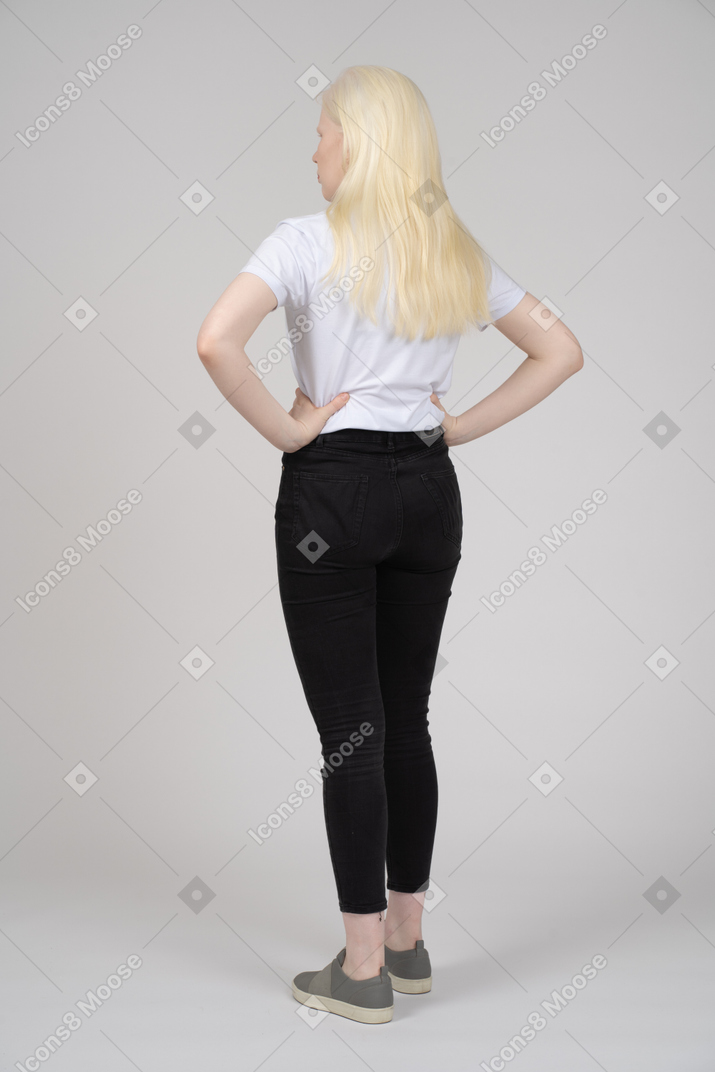 Back view of a blonde girl with hands on her waist