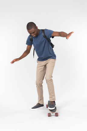 City male tourist standing on skateboard