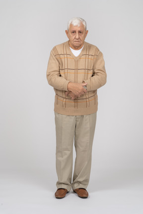 Front view of an old man in casual clothes standing still