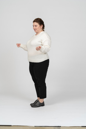 Vista lateral de uma mulher plus size com roupas casuais posando