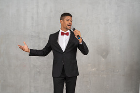 Mann im schwarzen anzug singt ins mikrofon