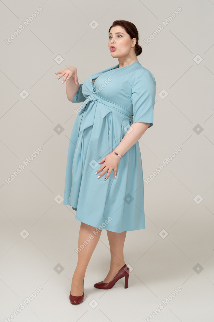 Vista laterale di una donna in abito blu che fa smorfie
