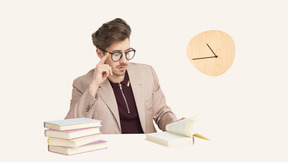 A man sitting at a table with books and a clock
