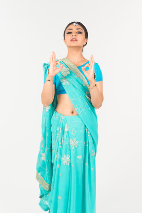 Young indian woman in blue sari standing in dance position