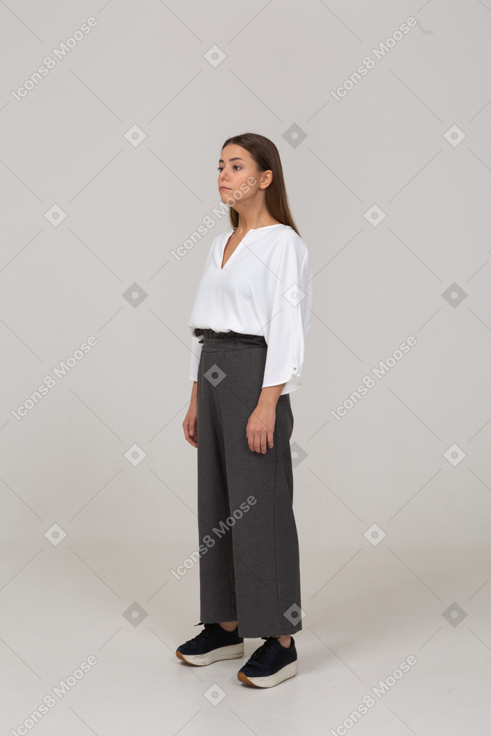 Three-quarter view of a young lady in office clothing looking aside