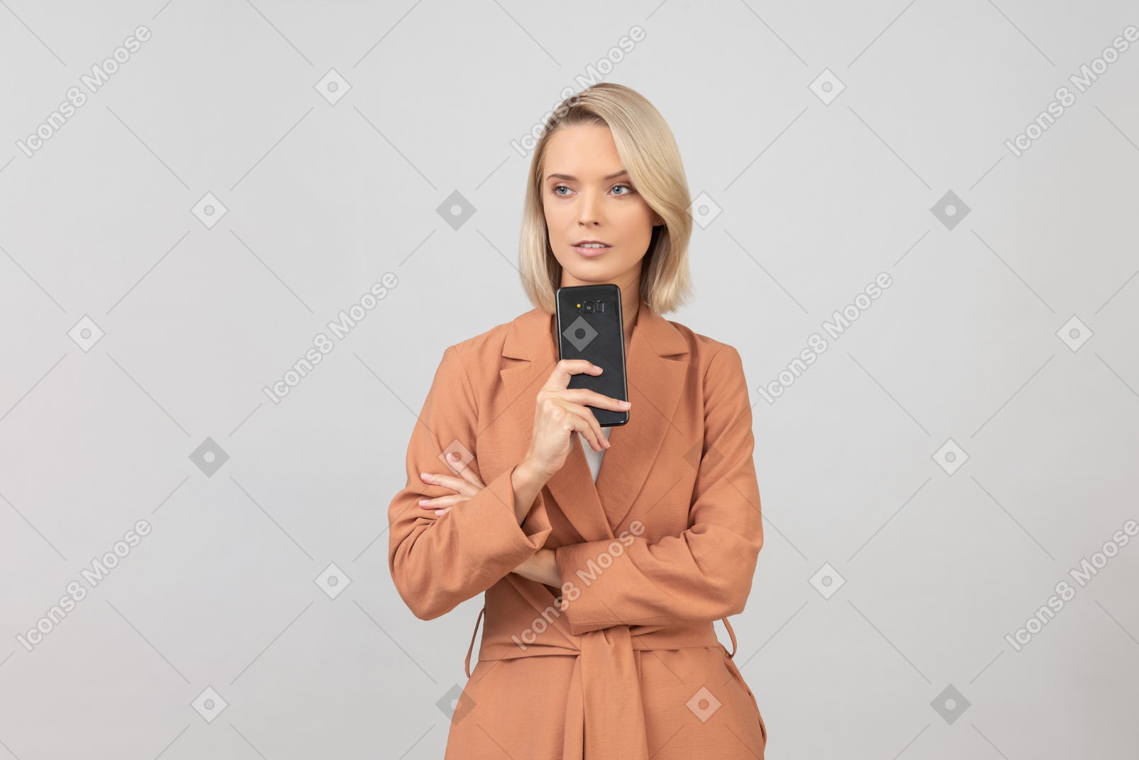 Созерцательная молодая женщина, держащая смартфон