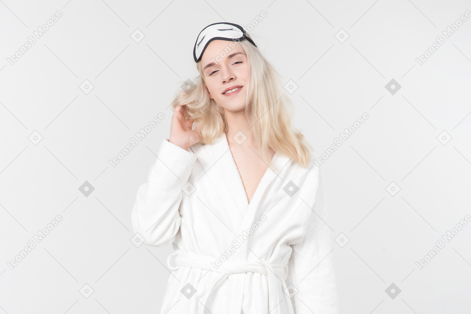 Young blond-haired man in a white bathrobe going about his morning routine
