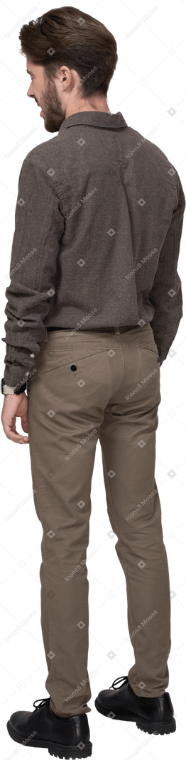 Vue de trois quarts arrière d'un jeune homme béant en vêtements de bureau