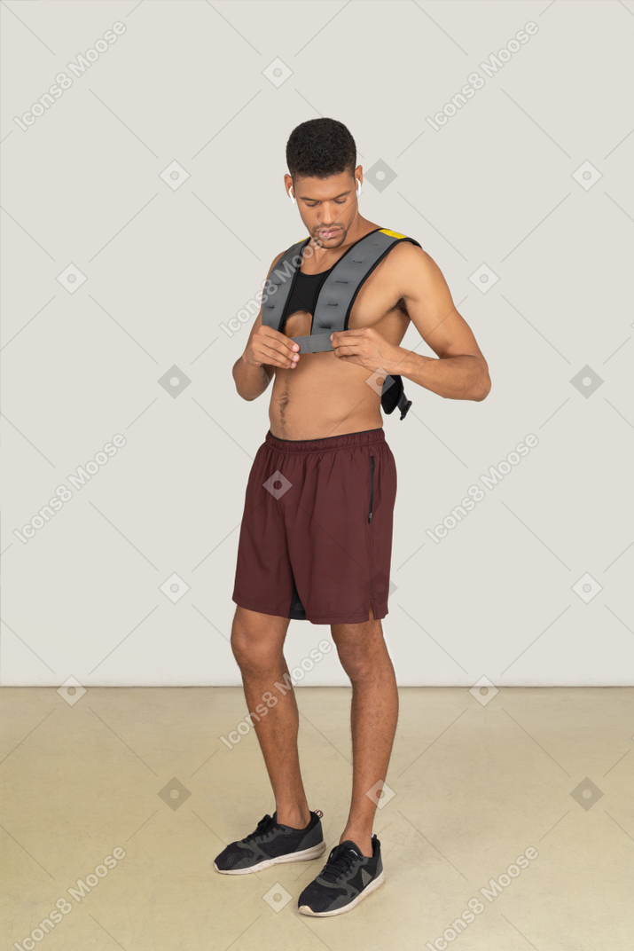 A three-quarter side view of the muscular man wearing a life vest