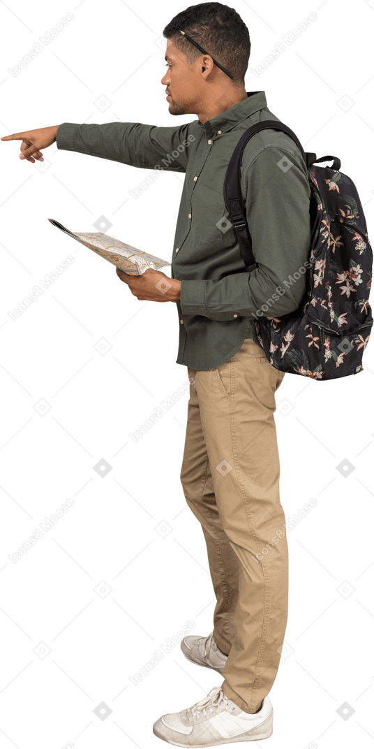 Вид сбоку на человека с рюкзаком, смотрящего на карту и указывающего в сторону