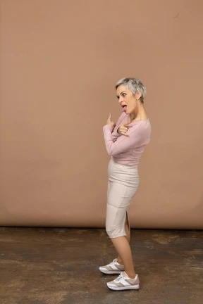 Woman in casual clothes posing in profile and making faces
