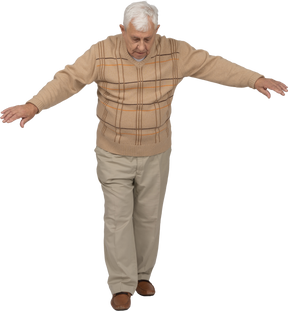 一位穿着休闲服的老人张开双臂向前走的正面图