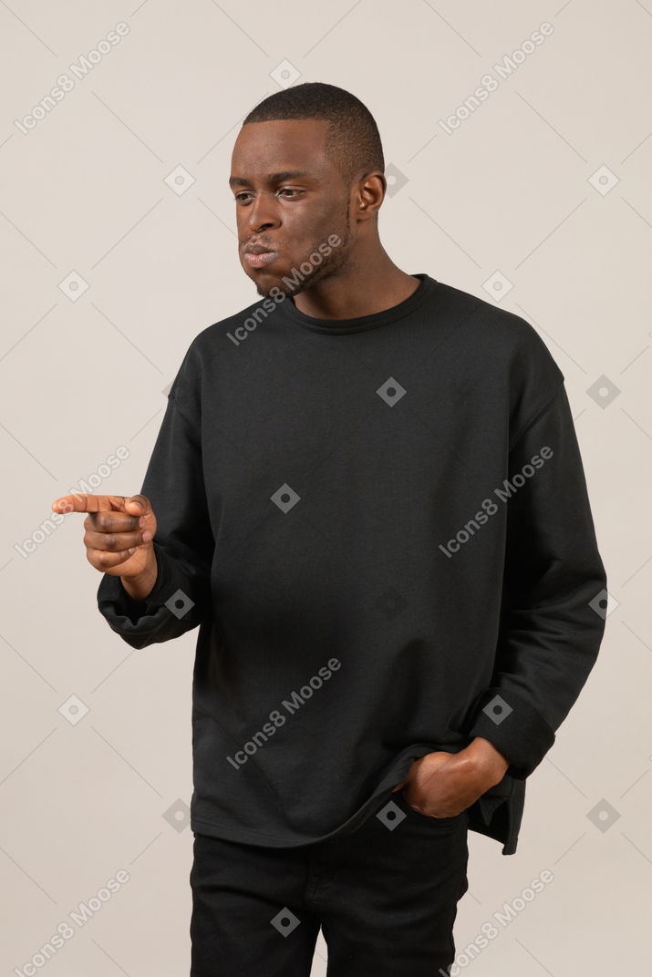 Man puffing cheeks and pointing at something