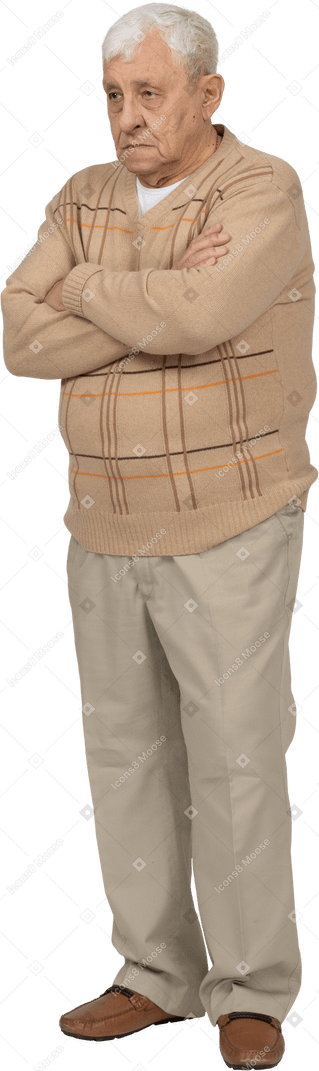 Vista frontal de um velho em roupas casuais em pé com os braços cruzados