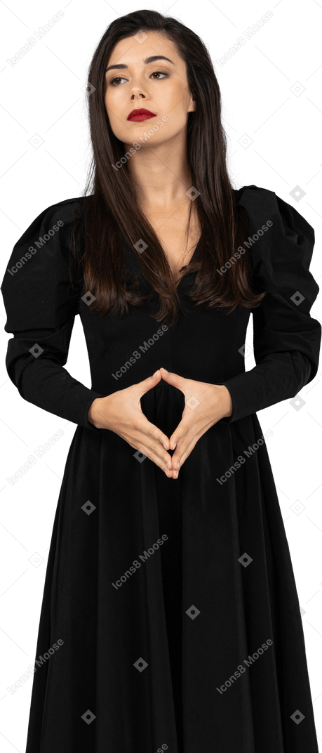 一个专横的年轻女士，穿着黑色连衣裙，手牵着手的前视图