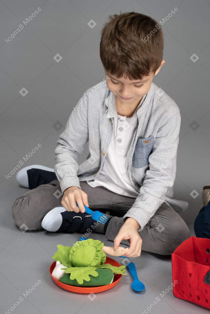 A little boy playing with food toys