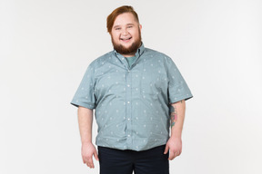 A fat man standing and smiling widely