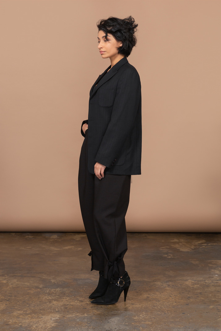 Three-quarter view of a sleepy businesswoman dressed in a black suit