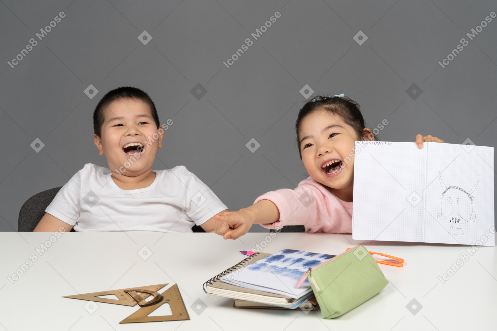 동생을 가리키며 웃고 있는 어린 소녀