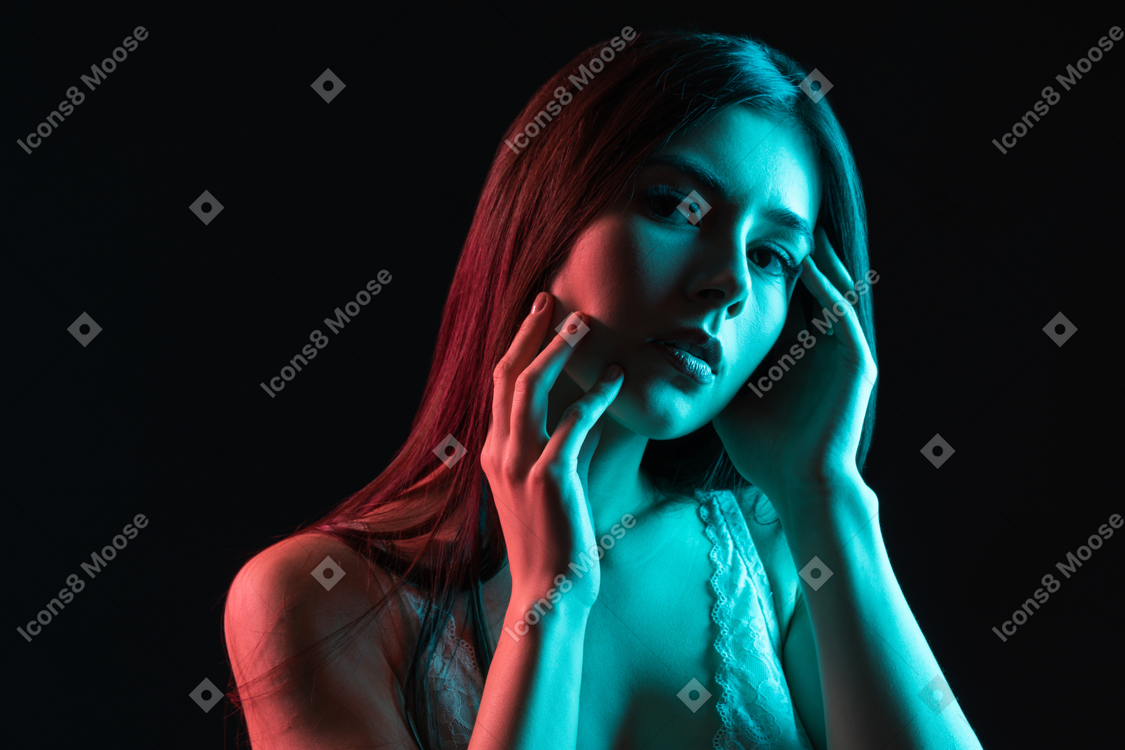 A young female under red and blue neon lights touching her face