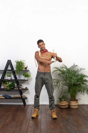 Athletic young man cutting off rope with a blade